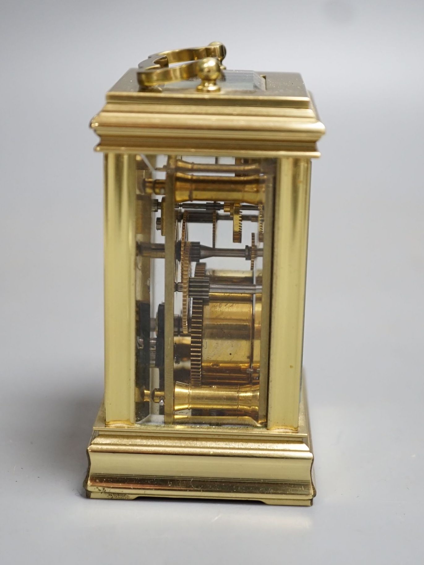 A small brass carriage time piece and key 9cm